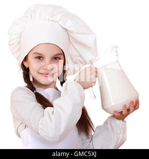 La cuisine et les gens concept - petite fille dans un tablier blanc tenant une cruche de lait, isolé sur fond blanc Banque D'Images