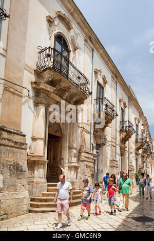 Les touristes en passant devant le Palais Spadaro, Via Francesco Mormino Penna, Scicli, Sicile, Italie Banque D'Images