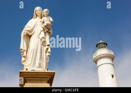 Statue de Marie portant Jésus, et le phare, Punta Secca, Donnalucata, Sicile, Italie Banque D'Images