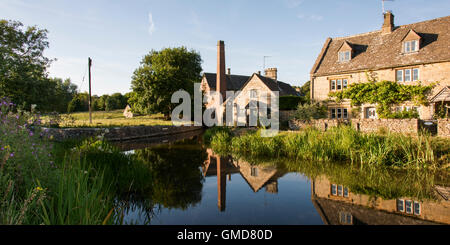 L'ancien moulin sur la rivière qui serpente à travers des yeux le magnifique village des Cotswolds de Lower Slaughter Banque D'Images