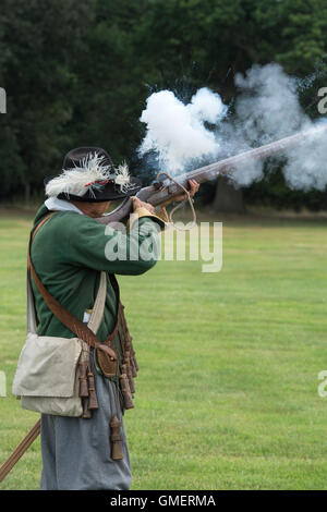 Guerre civile anglaise soldat royaliste tirant son mousquet à une reconstitution, Spetchley Park, Worcestershire, Angleterre. Banque D'Images