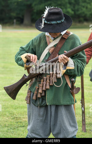 Guerre civile anglaise soldat royaliste préparer son mousquet à une reconstitution, Spetchley Park, Worcestershire, Angleterre. Banque D'Images