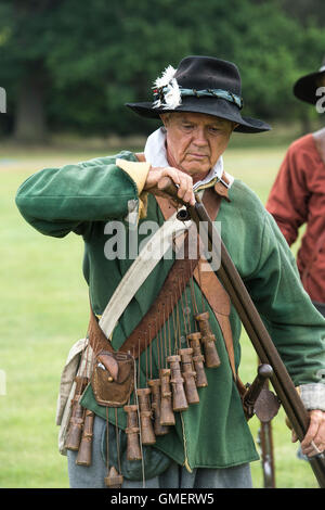 Guerre civile anglaise soldat royaliste préparer son mousquet à une reconstitution, Spetchley Park, Worcestershire, Angleterre. Banque D'Images