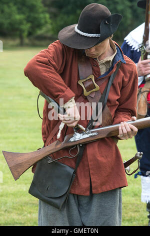 Guerre civile anglaise soldat royaliste préparer son mousquet à une reconstitution, Spetchley Park, Worcestershire, Angleterre. Banque D'Images