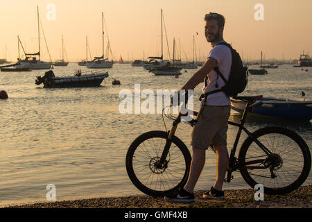 L'île de Mersea, Essex, le 25 août 2016. Un cycliste bénéficie de la lumière du soleil du soir, sur l'eau à West Mersea. Crédit : Paul Davey/Alamy Live News Banque D'Images