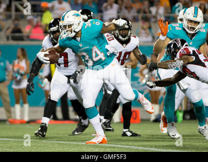 Orlando, Floride, USA. Août 25, 2016. Running back des Dolphins de Miami Arian Foster (34) gambade dans la zone des buts pour un touché au deuxième trimestre au Camping World Stadium à Orlando, Floride, le 25 août 2016. Credit : Allen Eyestone/Le Palm Beach Post/ZUMA/Alamy Fil Live News Banque D'Images