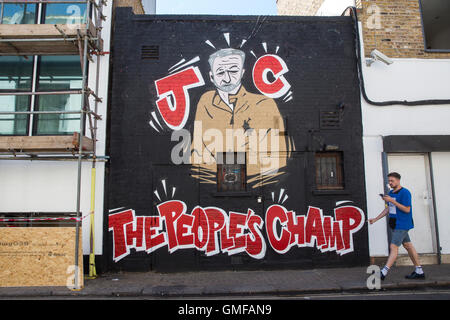 Londres, Royaume-Uni. Août 26, 2016. Un homme marche par un mur peint à l'appui de la chef du Parti du travail de Jeremy Corbyn le London Borough of Camden. Corbyn se bat contre Owen Smith à la direction du Parti du travail qui va être décidée le 24 septembre 2016. Crédit : Joel Ford/Alamy Live News Banque D'Images