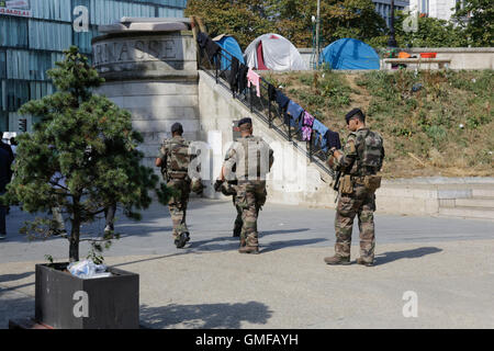 Paris, France. 26 août 2016. Soldats français lourdement armés en tenue de camouflage patrouiller la zone dans des intervalles réguliers. Des centaines de réfugiés sont à la rue dans les rues autour du métro Stalingrad à Paris. Ils sont toujours dans le thread d'être déplacé par la police française, comme cela se produit sur une base régulière. Certains attendent que leur demande d'asile en cours d'approbation, d'autres sont en route vers le camp à Calais. Crédit : Michael Debets/Alamy Live News Banque D'Images