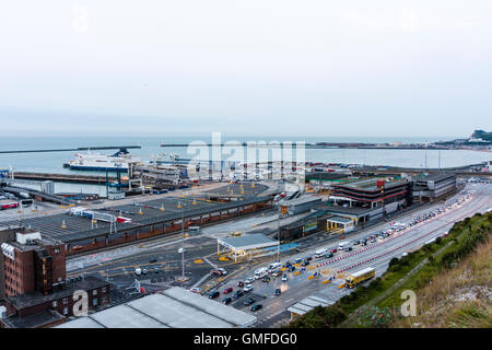 L'Angleterre, Dover, port. Au sommet d'une falaise et vue sur le port et les quais. Des files d'attente de voitures de contrôle de passeport français en premier plan, avec le fond du port et ferry, la première lumière tôt le matin. Couvert. Grand angle de vue. Banque D'Images