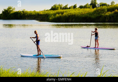 Deux femmes blanches d'âge moyen on stand up paddleboards sur la North Canadian river, New York, USA. Banque D'Images