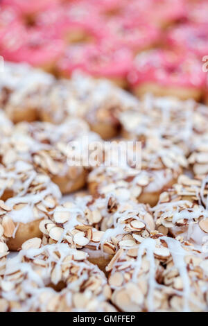 Beignets aux amandes avec glaçage blanc et rose donuts avec sprinkles Banque D'Images