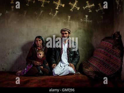 Famille afghane à l'intérieur de leur maison traditionnelle avec les Murs du Pamir décorées pour le Norouz, province de Badakhshan, Afghanistan, Zebak Banque D'Images