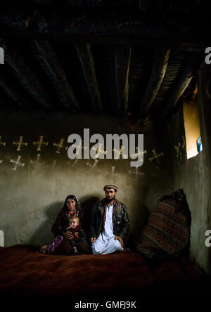 Famille afghane à l'intérieur de leur maison traditionnelle avec les Murs du Pamir décorées pour le Norouz, province de Badakhshan, Afghanistan, Zebak Banque D'Images