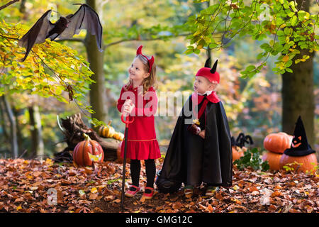 Deux drôles kids wearing devil costume vampire et avec des cornes rouges et trident trick or treating sur Halloween. Banque D'Images