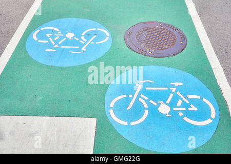 Signes sur un piste cyclable route peint en vert. Banque D'Images