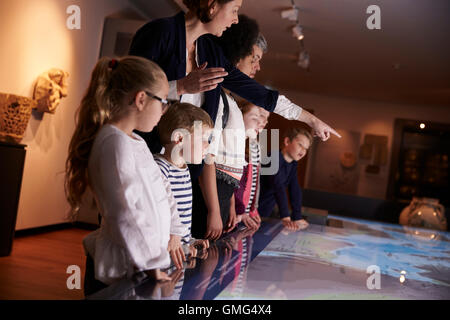 Les élèves sur le terrain de l'école Voyage à Museum Looking At Map Banque D'Images