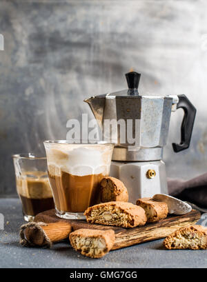Verre de café latte en bois rustique, conseil sur les cantucci biscuit et de l'acier Moka italienne pot, fond gris