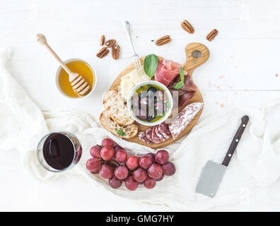 Apéritif vin ensemble. Verre de vin rouge, les raisins, le fromage parmesan, viandes diverses, tranches de pain Banque D'Images