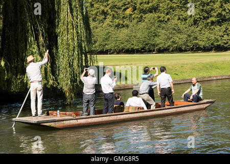 Les touristes en barque sur la rivière Cam sur le dos à Cambridge UK en été debout dans le bateau en prenant des photographies Banque D'Images