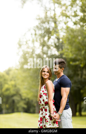 Jeune couple dans l'amour debout dans le parc et tenir la main Banque D'Images