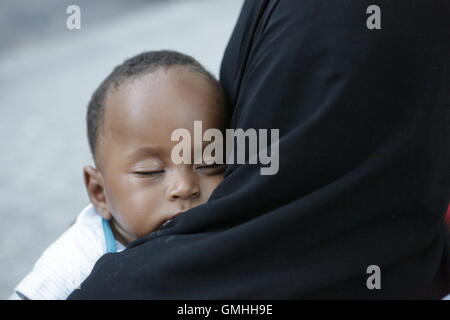 Paris, France. Août 25, 2016. Un peu à l'âge de six mois, bébé garçon soudanais est en train de dormir sur l'épaule de sa mère. Des centaines de réfugiés sont à la rue dans les rues autour du métro Stalingrad à Paris. Ils sont toujours dans le thread d'être déplacé par la police française, comme cela se produit sur une base régulière. Certains attendent que leur demande d'asile en cours d'approbation, d'autres sont en route vers le camp à Calais. © Michael Debets/Pacific Press/Alamy Live News Banque D'Images