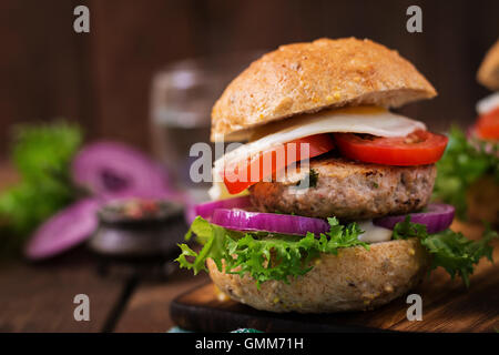 Hamburger (Sandwich) avec burger de poulet, salade, tomate, œuf frit et sauce tartare Banque D'Images