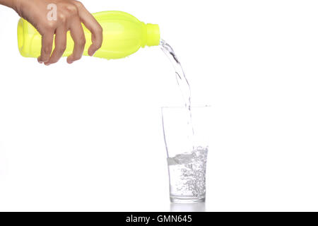 Les femmes verser de l'eau dans le verre isolé en fond blanc. Banque D'Images