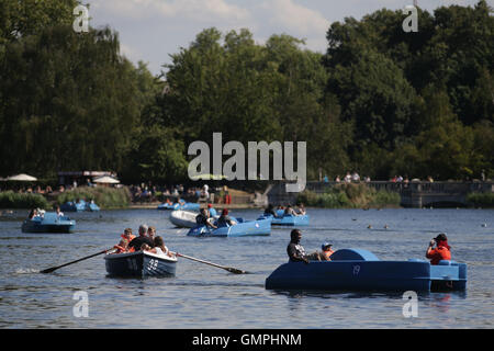 Les personnes utilisant des pédalos et des bateaux à rames sur la Serpentine dans Hyde Park, Londres, au cours d'une journée ensoleillée et chaude. Banque D'Images