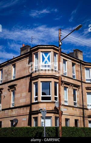 Glasgow tenement télévision avec sautoir drapeau dans fenêtre. Banque D'Images