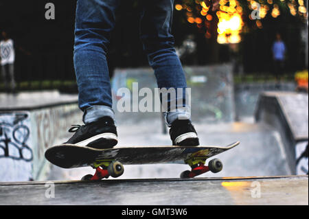 gros plan de jeune homme pied jouant au skateboard dans le skate park Banque D'Images