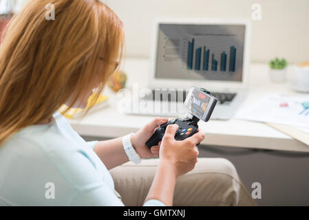 Cheerful woman playing video games Banque D'Images