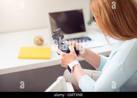 Senior femme agréable à jouer à des jeux vidéo. Banque D'Images