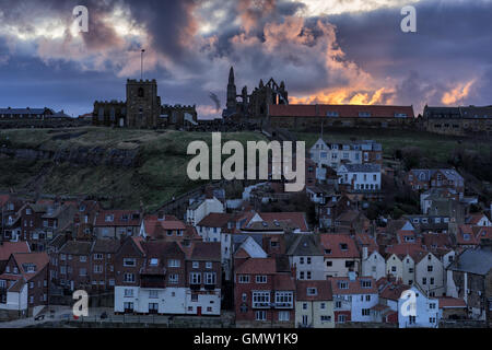 Vieille ville de Whitby avec coucher du soleil derrière, montrant l'abbaye de Whitby, l'église St Mary et les 199 marches Banque D'Images