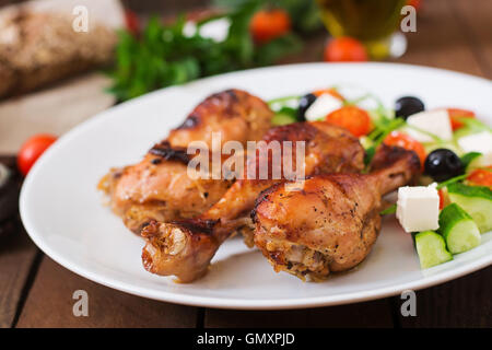 Appétissants pilons de poulet doré au four et salade grecque Banque D'Images