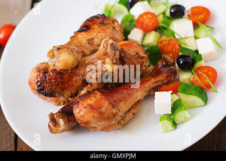 Appétissants pilons de poulet doré au four et salade grecque Banque D'Images