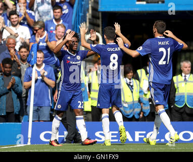 Willian Chelsea's (à gauche) célèbre marquant son deuxième but de côtés du jeu avec ses coéquipiers Oscar et Nemanja Matic (à droite) au cours de la Premier League match à Stamford Bridge, Londres. Banque D'Images