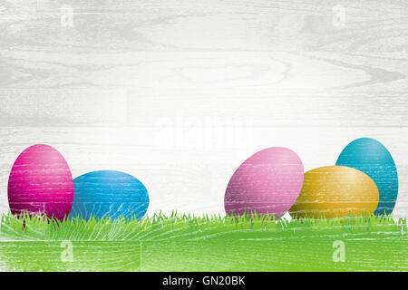 Les oeufs de Pâques colorés et de l'herbe peint sur une planche de bois blanc, de conseil. Banque D'Images