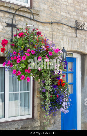 Paniers suspendus à l'extérieur d'un chalet à Stow on the Wold, Cotswolds, Gloucestershire, Angleterre Banque D'Images