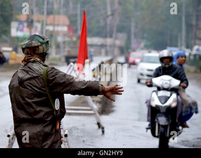 Srinaga, au Cachemire. Août 27, 2016. Un homme s'arrête l'armée indienne un scooter de Srinagar, la capitale d'été du Cachemire sous contrôle indien. Plus tôt la direction conjointe de séparatistes avaient demandé aux gens de marcher vers le cantonnement de l'armée de Badami Bagh et demandez-leur de libérer du Cachemire. Des restrictions sévères imposées par le gouvernement d'arrêter les personnes déménagement au camp de l'armée. Credit : Muzamil Mattoo/Alamy Live News Banque D'Images