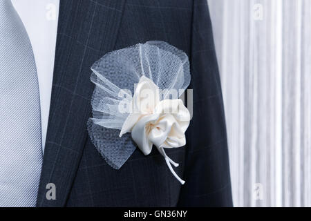 Le marié en costume de mariage avec décoration de poche sur l'avant du rideau de lumière sur la fenêtre Banque D'Images