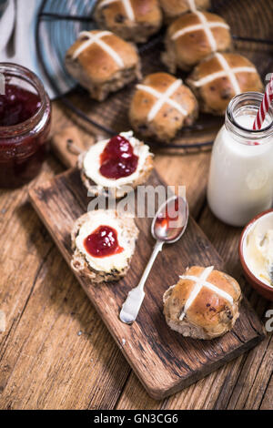 Thé chaud crémeux, cross bun avec de la confiture et de la crème caillée Banque D'Images