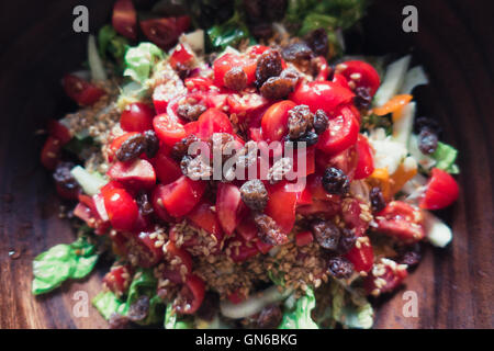 Salade d'été avec des tomates et les graines dans un bol en bois sultana Banque D'Images