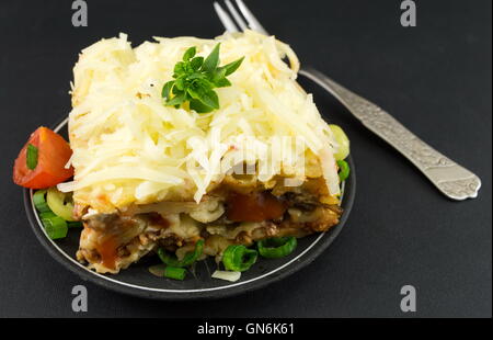 Portion de lasagne aux légumes sur un tableau sombre Banque D'Images