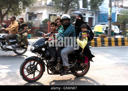 Une famille de quatre personnes dont un bébé rides une moto construite pour deux à Agra dans l'Uttar Pradesh, Inde. Banque D'Images