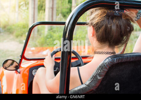 Femme au volant d'une voiture orange sport convertible Banque D'Images