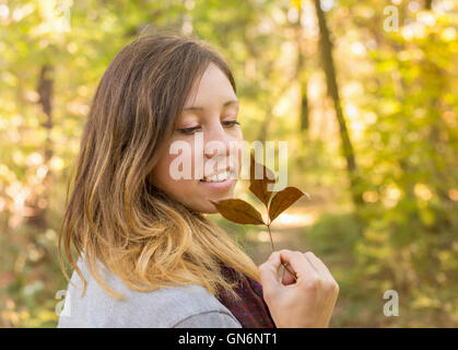 Happy woman holding feuille d'automne dans le parc Banque D'Images