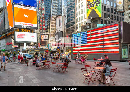 Les gens apprécient le coin dans la zone piétonne plazas dans Times Square dès le matin un week-end dans la ville de New York. Banque D'Images