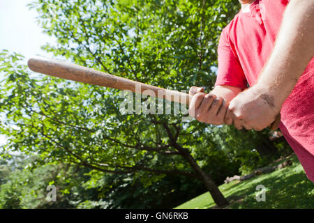 Homme tenant une batte de baseball en bois prépare à swing en légitime défense - USA Banque D'Images