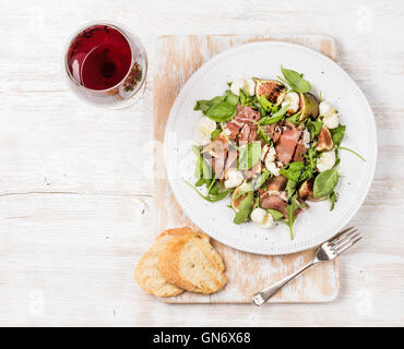 Le prosciutto, roquette, figues salade avec tranches de baguette et vin Banque D'Images