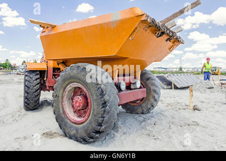 Peu de construction est à l'opérateur de la benne chantier. Banque D'Images